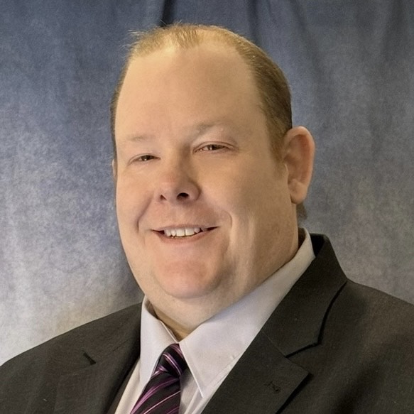 Professional square headshot of David Rumelhart in business attire on a neutral background.